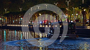 The bright lights of the night city are reflected in the water. Dark time of day during an hour in a big city on the