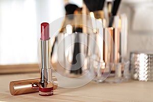 Bright lipstick in gold on dressing table, space for text