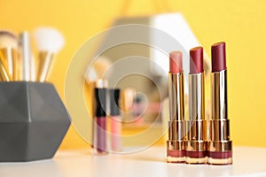 Bright lipsticks in gold tubes on dressing table