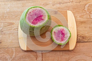 Bright magenta and green watermelon radish o a cutting board