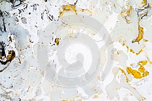 Bright marble background texture with gold, black, grey and white colors, using acrylic pouring medium art technique. Useful as a