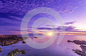 Bright marvelous bright sunset and rocky seacost