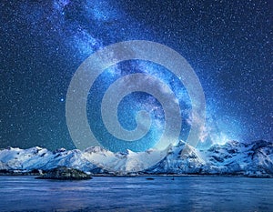 Bright Milky Way over snow covered mountains and sea at night photo