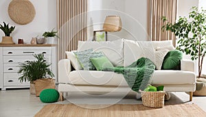 Bright modern living room interior with comfy white sofa and green accents