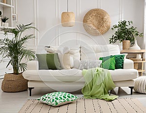 Bright modern living room interior with comfy white sofa and green accents