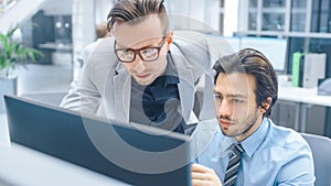 In Bright Modern Office: Handsome Office Worker Sitting and Working at His Desktop Computer, Discu