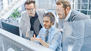 In Bright Modern Office: Office Worker Sitting and Working at His Desktop Computer, Discusses Prob