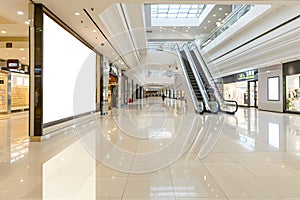 Bright modern shopping mall interior with escalators