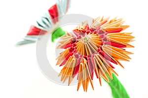 Bright modular origami orange and red flower isolated on white background