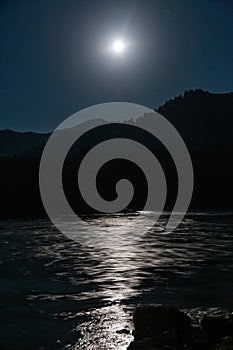 Bright moon over the mountain river Katun in Altai, Russia