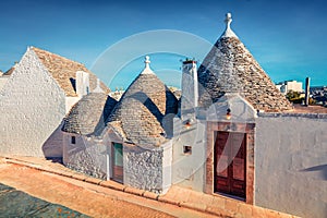 Bright morning view of strret with traditional Apulian dry stone hut with a conical roof photo