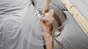 Bright morning wake-up for young beautiful hispanic woman, confidently stretching arms in cozy bed, basking in the comfort of her