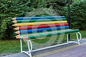 Bright multi-color pencil rainbow bench in park