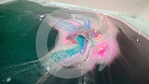 Bright multi-colored handmade bath bomb dissolves