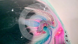 Bright multi-colored handmade bath bomb dissolves