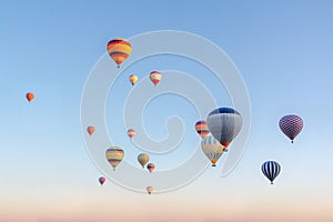 Bright multi-colored hot air balloons flying in sunsrise sky