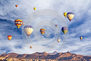 Bright multi-colored hot air balloons flying in sunsrise sky