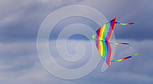 Bright multi-colored kite in free flight above the ground