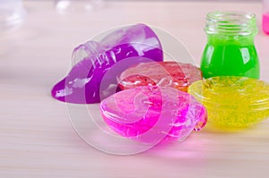 Bright multi colored slimes on a table. Kids popular toy of nowadays. Slime in plastic containers