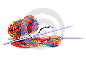 Bright multi-coloured colorful knitting wool or yarn with knitting needles on white background