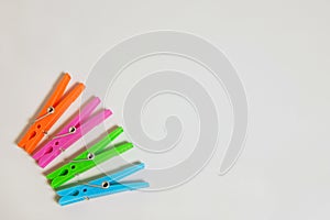 Bright multicolored clothespins on gray background with copy space