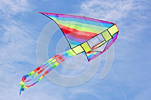Bright multicolored kite in blue sky