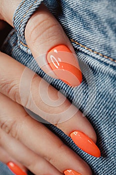 Bright neon manicure on female hands on the background of jeans. Nail design.