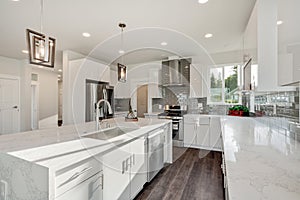 Bright and neutral kitchen with a large marble waterfall island