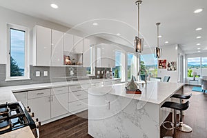 Bright and neutral kitchen with a large marble waterfall island