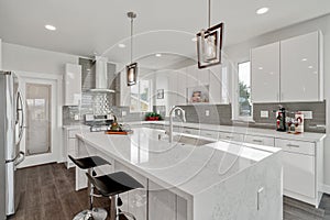 Bright and neutral kitchen with a large marble waterfall island