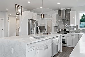 Bright and neutral kitchen with a large marble waterfall island