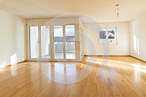 Bright new living room in an empty apartment with french doors and parquet wooden floors