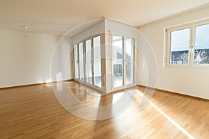 Bright new living room in an empty apartment with french doors and parquet wooden floors