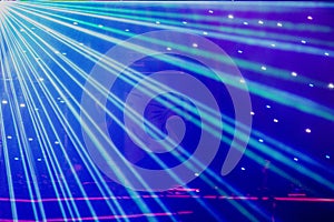 Bright nightclub purple, white, blue laser lights cutting through smoke machine smoke making light and rainbow patterns