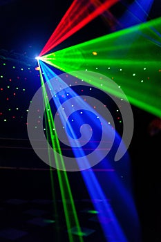 Bright nightclub red, green, purple, white, pink, blue laser lights cutting through smoke machine smoke making light patterns photo