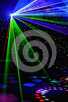 Bright nightclub red, green, purple, white, pink, blue laser lights cutting through smoke machine smoke making light and rainbow photo