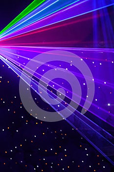 Bright nightclub red, green, purple, white, pink, blue laser lights cutting through smoke machine smoke making light patterns