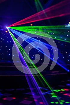 Bright nightclub red, green, purple, white, pink, blue laser lights cutting through smoke machine smoke making light and rainbow