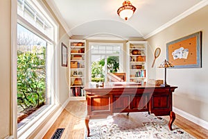 Bright office room with classic desk and built-in shelves