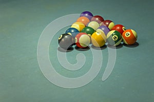 Bright old shabby multi-colored billiard balls on blue cloth