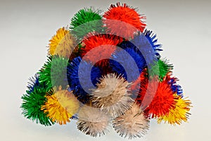 Bright, olourful pom poms in a pile