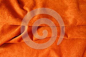 Bright orange artificial suede fabric in soft folds