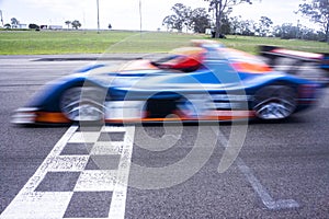 Car crossing finish line at racetrack