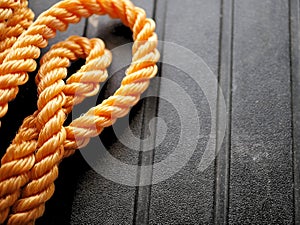 Bright orange braided nylon rope in tangled coil black background