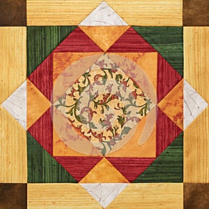 Bright orange-green geometric patchwork block from pieces of fabrics, detail of quilt