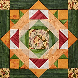 Bright orange-green geometric patchwork block from pieces of fabrics photo