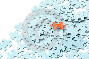 Bright orange puzzle piece and light blue puzzle pieces