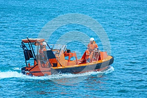 A orange rescue boat in the blue sea