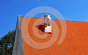 Bright orange roof with old brick trumpet on the site of Red stone castle, Slovakia