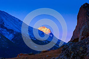 Sunset over blue Caucasian mountain peaks